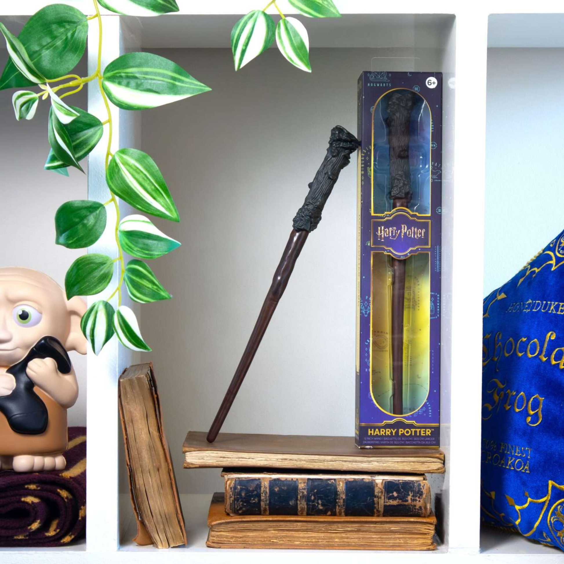 Harry Potter-themed wand on a wooden stand with packaging and decorative elements.